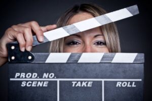 Woman holding black and white movie production clapboard